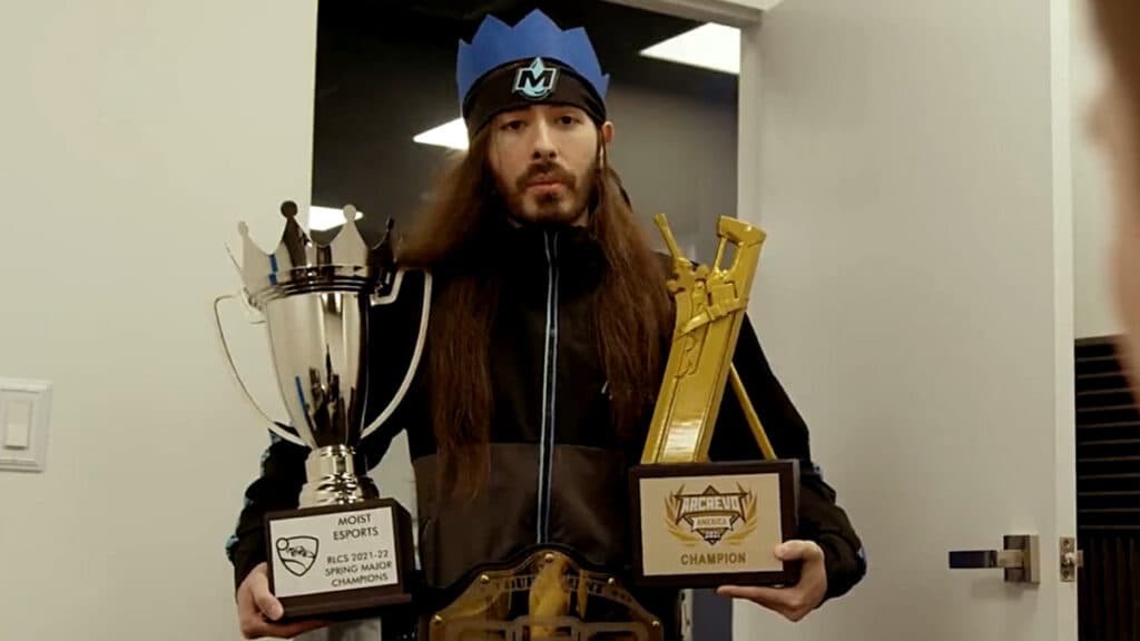MoistCr1TiKaL holding a Rocket League trophy won by Moist Esports.