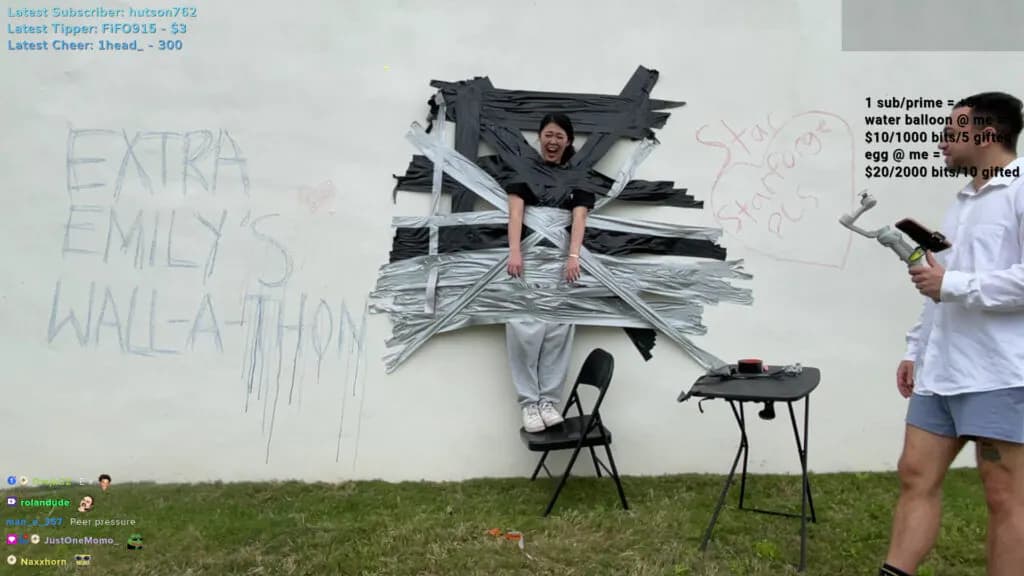 ExtraEmily taped to a wall (Screenshot taken via ExtraEmiy's Twitch)