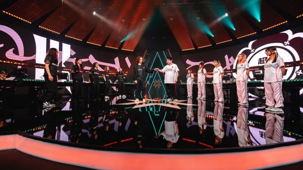 The two coaches bump fists as the player stands, ready to compete in Brazil (Photo by Adela Sznajder/Riot Games)