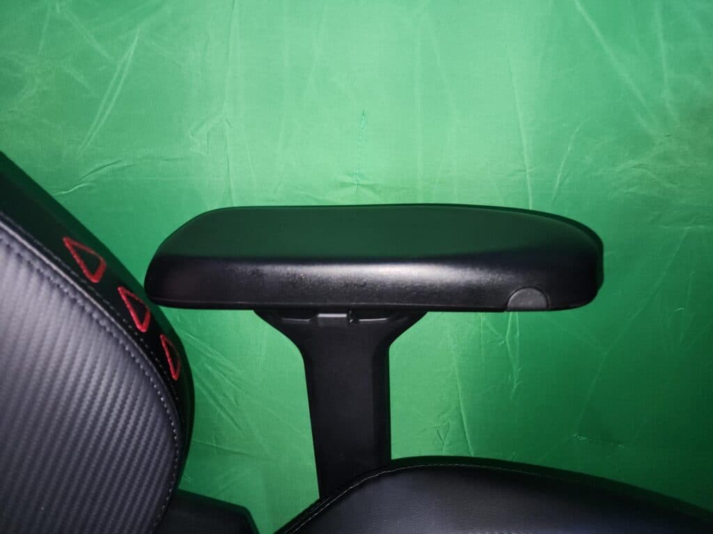The armrest has three buttons for adjustment, two of which are visible here. (Photo via esports.gg)