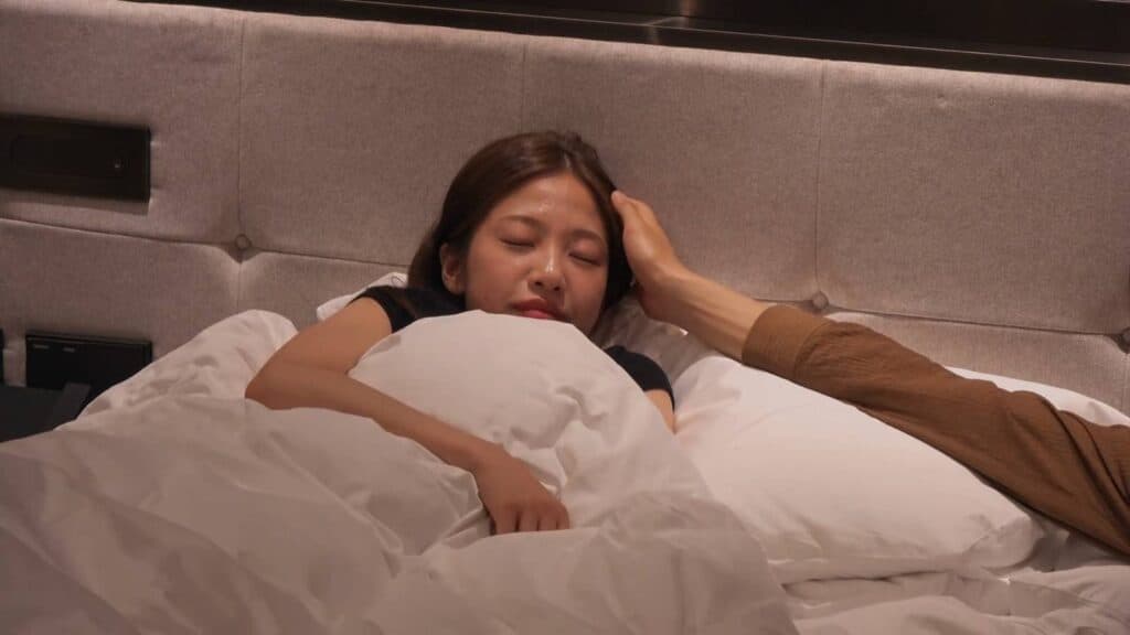 Lee Joo-young and Kim Jae-jin, touches in bed (Image via Netflix)